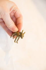 Small handmade African bronze impala pendant held in hand to show its scale.