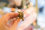 Vintage African bronze turtle pendant held in hand, showing its scale and texture.