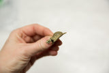 Angled view of the handmade African bronze turtle pendant with a mesh shell.