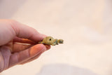 Vintage African bronze turtle pendant held in hand to show its small scale and charm.