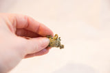 A detailed view of the handmade bronze wire wrapping on a turtle pendant.