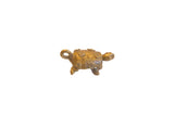 Vintage African bronze turtle pendant with a gold patina and spiral designs on its shell.