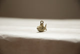 Angled view of the vintage African fish pendant highlighting its oxidized bronze mesh texture.