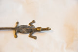 High-angle view of a vintage bronze crocodile showing the aged patina on its dark textured back.
