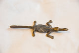 The dark, textured back and light patina on a handmade African bronze crocodile.