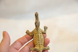 The segmented, textured back of a vintage African bronze crocodile sculpture.
