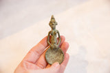 Vintage bronze Ashanti female spoon held in hand, showing its small scale and oxidized patina.