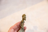 Side profile of a vintage Ashanti bronze gold weight showing hand-cast features and aged patina.