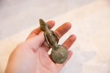 Vintage Ashanti bronze spoon held in hand, showing its scale and oxidized patina.