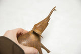 Side profile of a vintage African bronze elephant with raised trunk, showing rich, aged patina.