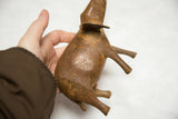 Hand holding vintage African bronze elephant, highlighting aged body, legs, and rich patina.