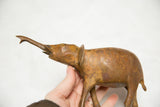 Hand holding vintage African bronze elephant, showcasing its rich, aged patina.