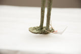 Rough texture and aged patina on the oxidized bronze base of the vintage stork figure.