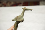 Side profile of a vintage bronze stork showing its textured neck and oxidized patina.