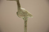 Close-up of the vintage bronze stork's back showing its textured patina.