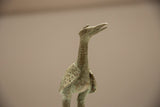 Detailed profile of the vintage bronze stork, focusing on its textured, oxidized surface.