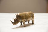 Vintage African bronze rhino figure with golden patina, viewed from its left side.