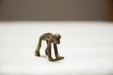 Side profile of a collectible bronze monkey showing the textured, ridged detail along its back.