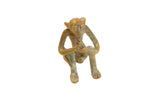 Vintage African oxidized bronze monkey figurine with green patina, holding banana, 1x1x2 inches.