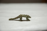 Side view of a vintage African pangolin sculpture showing its scaled body and aged bronze patina.