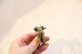 Small handmade African bronze ram sculpture held in hand to show its scale and form.