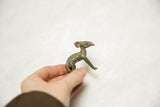 Vintage African bronze ewe sculpture held in hand, revealing its aged patina.