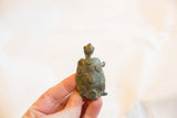 Vintage African turtle held in hand, showing its oxidized texture and raised circle designs.