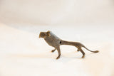 Vintage African dark bronze lion sculpture, showing aged texture and mid-body opening.