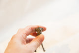 Vintage African dark bronze lion sculpture held in hand, showing its small size.