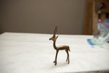 Side profile of a handmade copper gazelle showing its slender form and vintage patina.