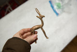 Vintage copper gazelle held in a hand to show its small, collectible size.
