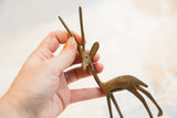 Hand holding the vintage bronze gazelle, showing its scale and handmade texture.