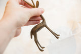 Vintage African bronze gazelle held in hand, showing its scale and aged patina.