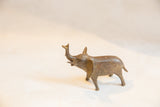 Side view of a vintage handmade bronze elephant sculpture with raised trunk and rustic patina.