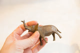 Hand-held vintage African bronze elephant, showcasing its textured surface and raised trunk.
