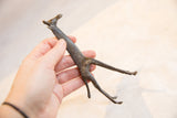 Vintage African bronze giraffe body with dark patina and etched patterns, held in hand.