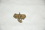 Angled view of a handmade brass elephant pendant highlighting its textured, vintage patina.