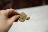Vintage elephant head pendant held in hand, showing its aged patina and small collectible size.