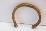 Detail of the antique African bracelet's warm copper patina and smooth, curved form.
