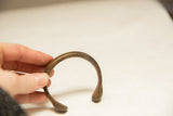 The smooth, curved form and aged bronze patina of a 19th-century African bracelet.