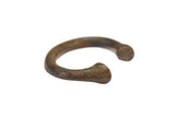 A vintage African bronze bracelet with a thick, curved form and a dark, time-worn patina.