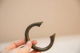 Vintage African bronze bracelet showing its curved shape and rich, textured patina.