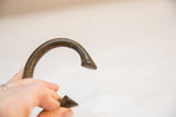 The curved form and textured, time-softened patina of a vintage bronze bracelet.