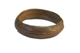 Vintage African bronze bracelet with time-softened tones, etched patterns, and raised bands.