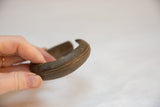 Engraved lines and aged, time-softened bronze on the vintage African bracelet's side.