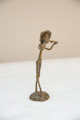 Side view of the vintage bronze musician statue, highlighting its slender handmade form.