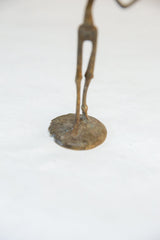 Detail of the aged patina and handmade texture on the round bronze statue base.
