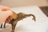 Hand holds the vintage African elephant sculpture, its light patina and upward trunk visible.