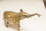Angled view of a vintage golden elephant sculpture showing handmade details on the head.