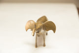 A vintage golden elephant sculpture viewed face-on, showing its textured trunk and wide ears.